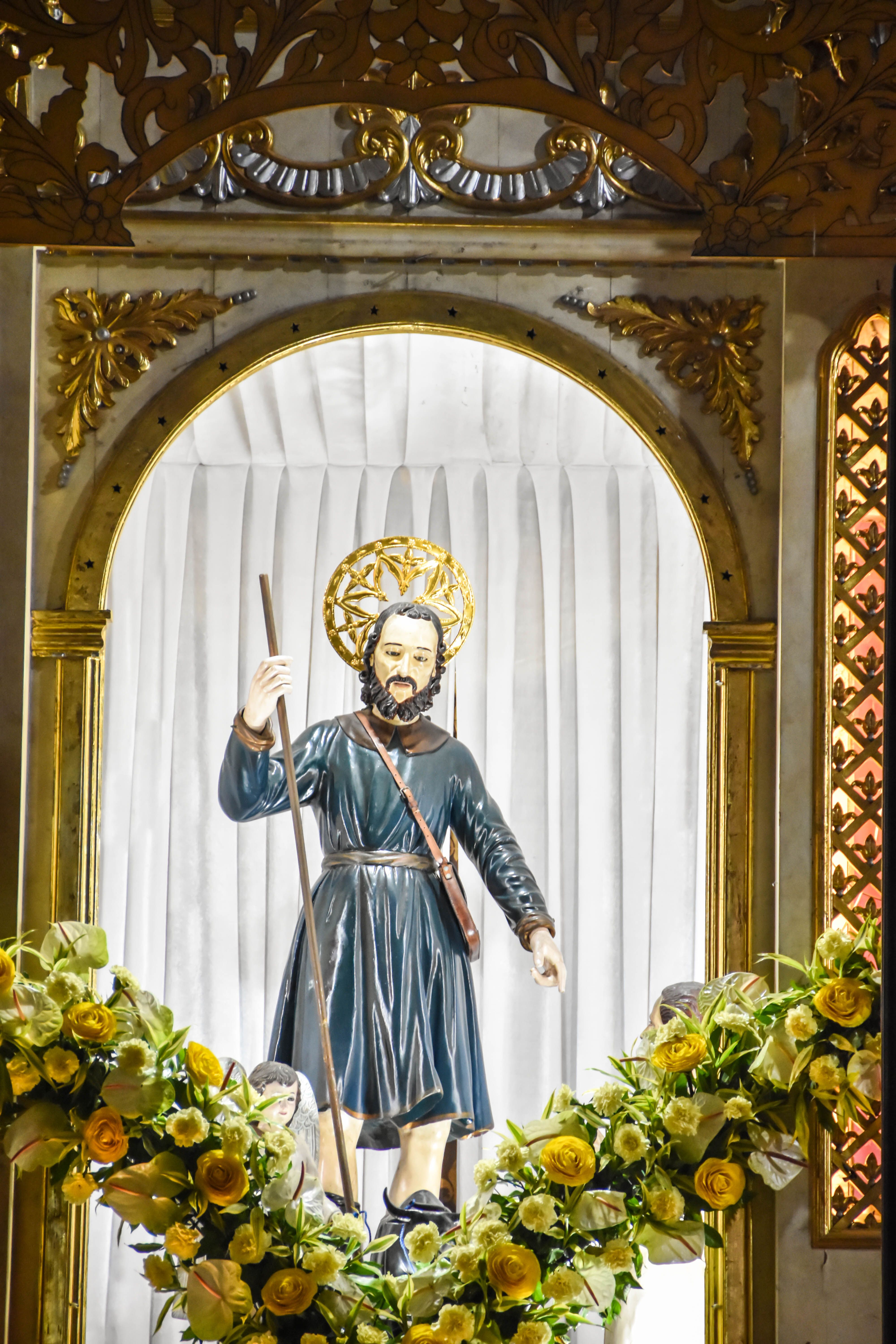 Statue of Saint Isidore in Pulilan, Philippines adorned with flowers.
