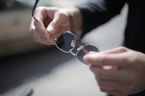 Person Holding Silver Framed Aviator Style Sunglasses