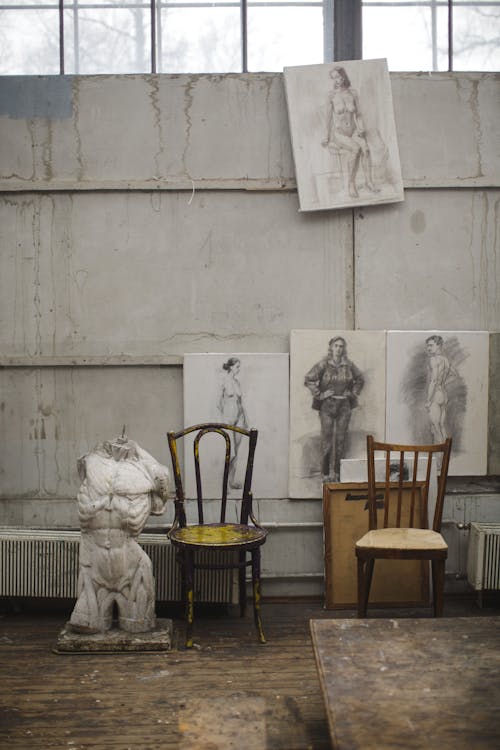 White Concrete Statue Near Brown Wooden Chairs