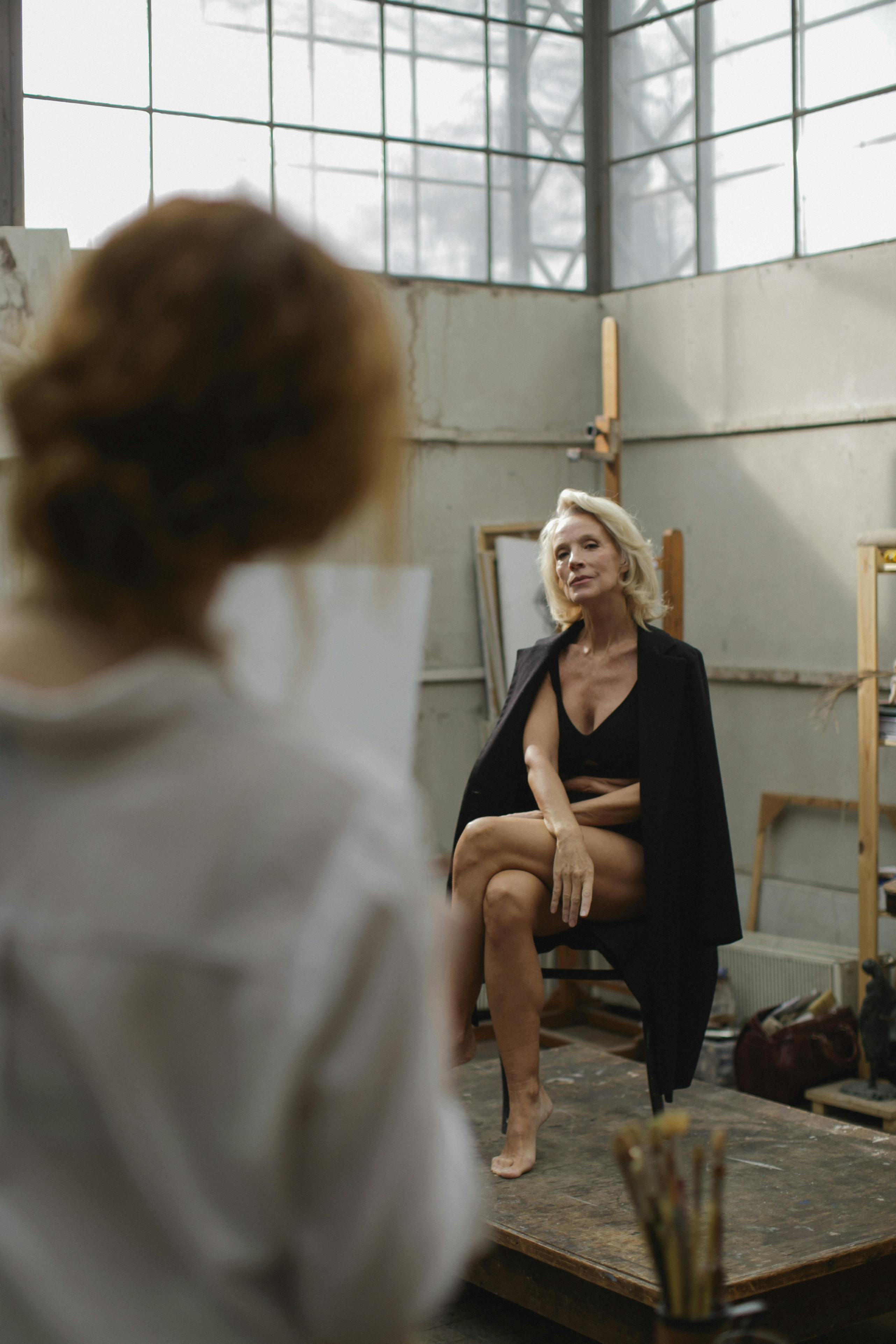 Gratis Wanita Dengan Gaun Tanpa Lengan Hitam Duduk Di Kursi Foto Stok