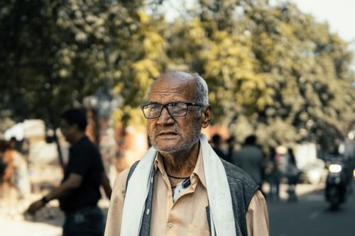 Free Senior man walking on a bustling street in Ludhiana, Punjab, India with a thoughtful expression. Stock Photo