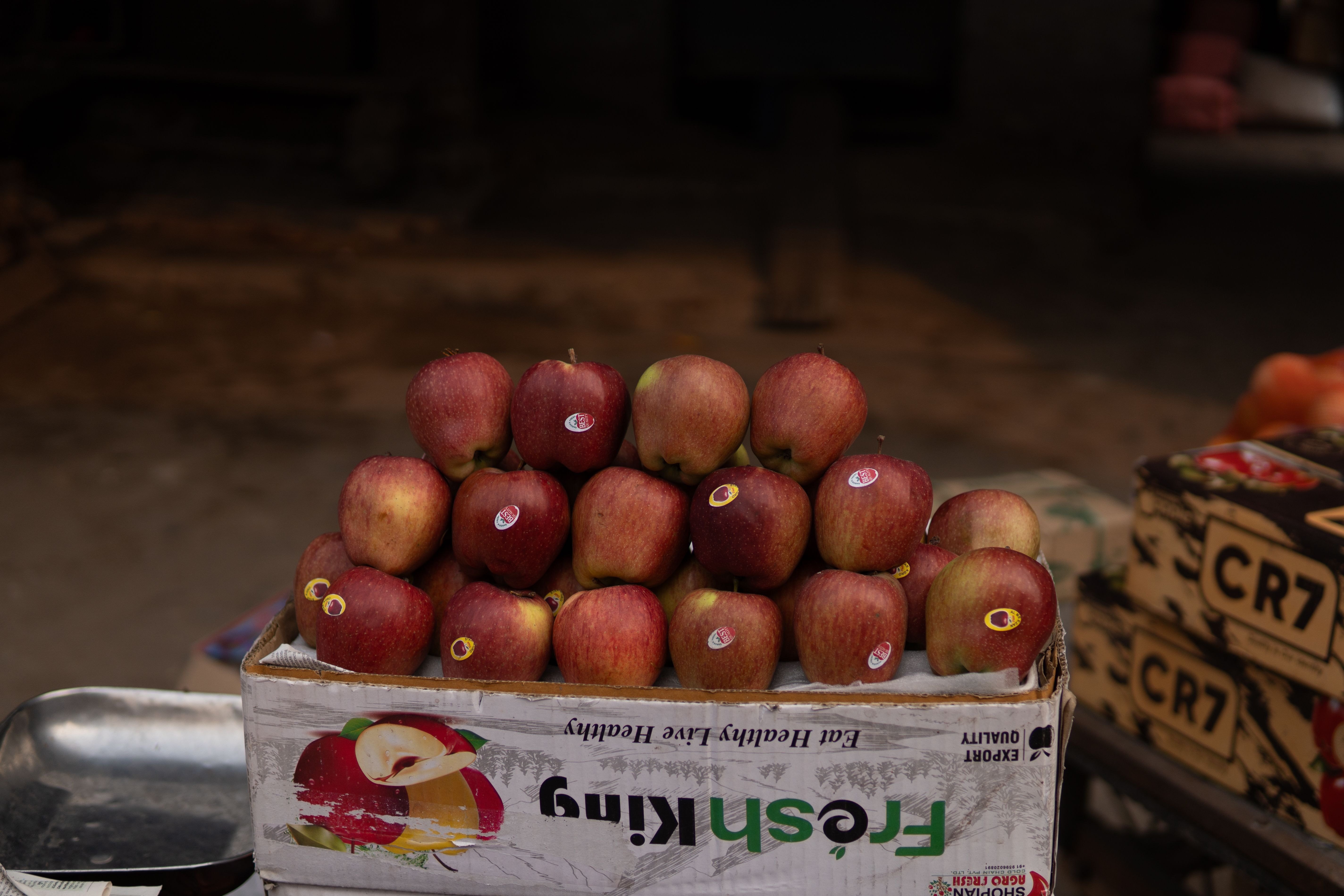 Fresh red apples neatly stacked in a box at Ludhiana street market, capturing a slice of local comme