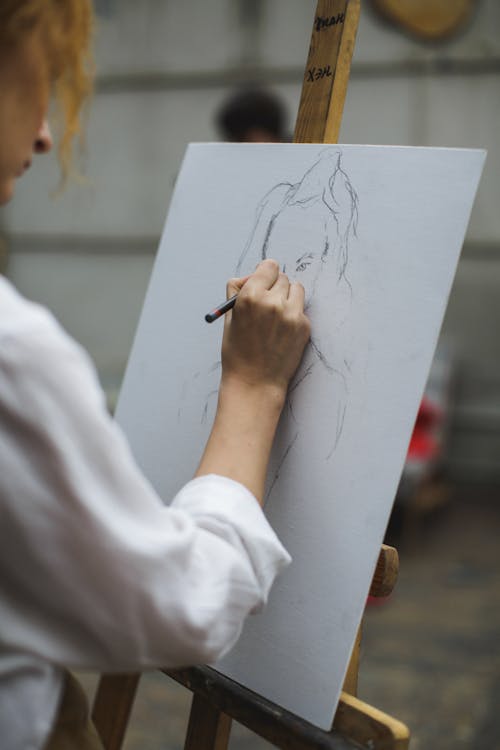 白色长袖衬衫在纸上画画的女人