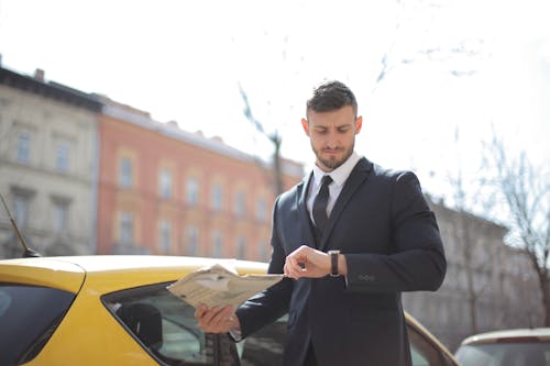 Man In Black Suit Standing Beside The Yellow Car