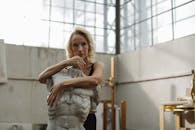 工作室里，一名妇女拥抱雕塑半身像，流露出创造性的内省