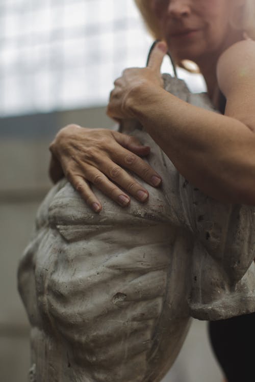 Free Photo of Elderly Woman Hugging a Statue Stock Photo