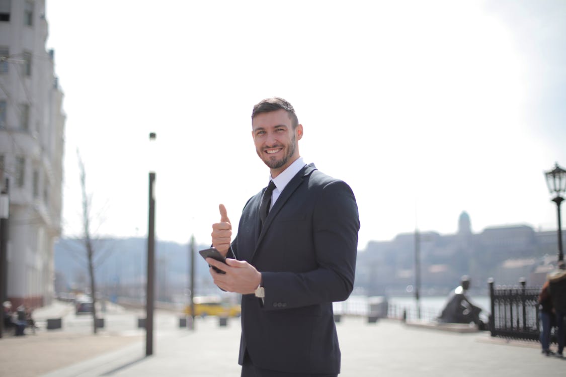 Free Man in Black Suit Jacket While Holding a Smartphone Stock Photo