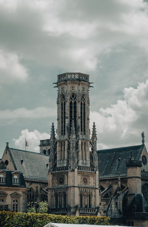 Free Stunning view of a Gothic cathedral's tower under cloudy skies in Paris, showcasing intricate architectural details. Stock Photo