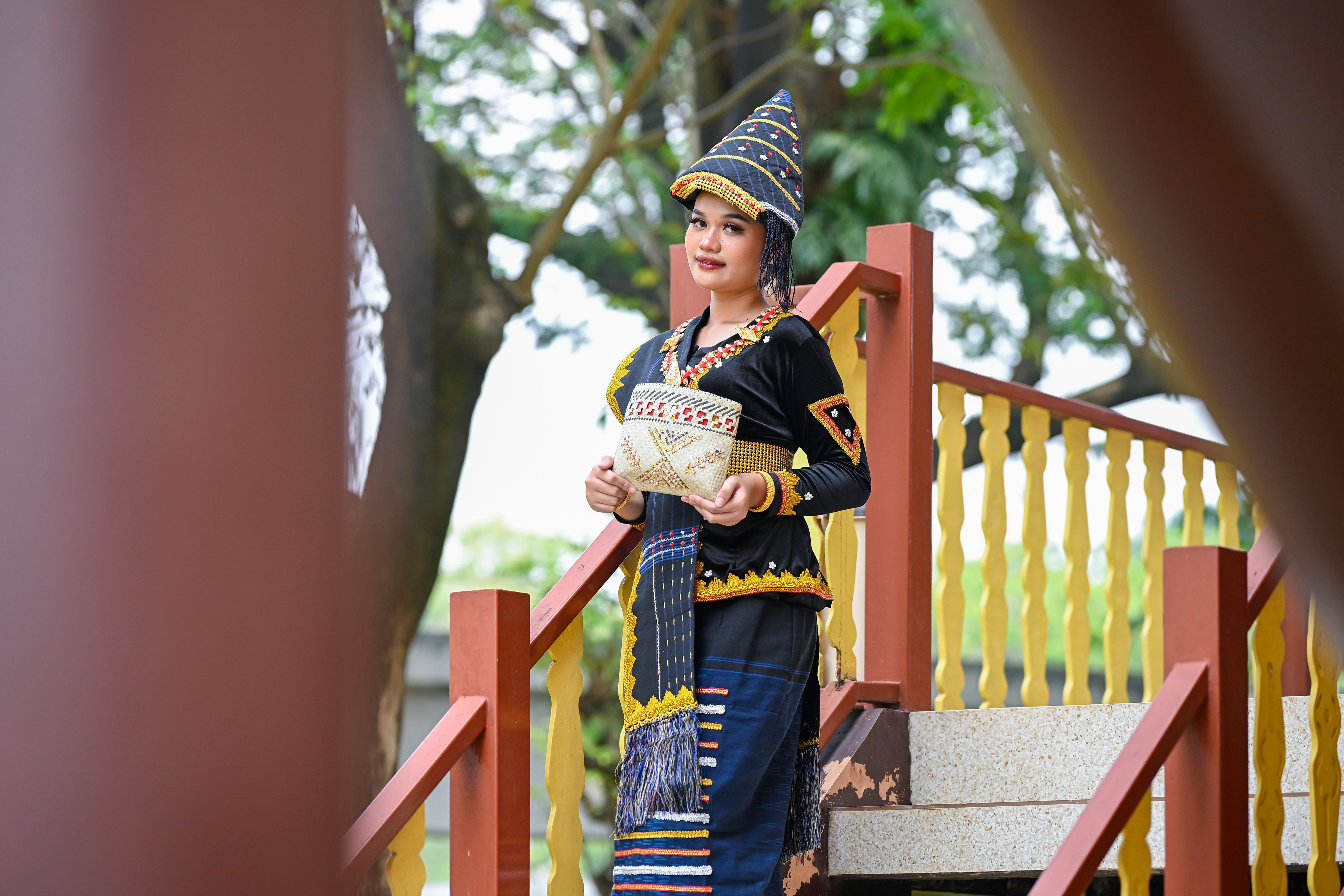 Gratuit Jeune femme en tenue ethnique traditionnelle posant à l'extérieur sur un escalier, mettant en valeur le patrimoine culturel. Photos