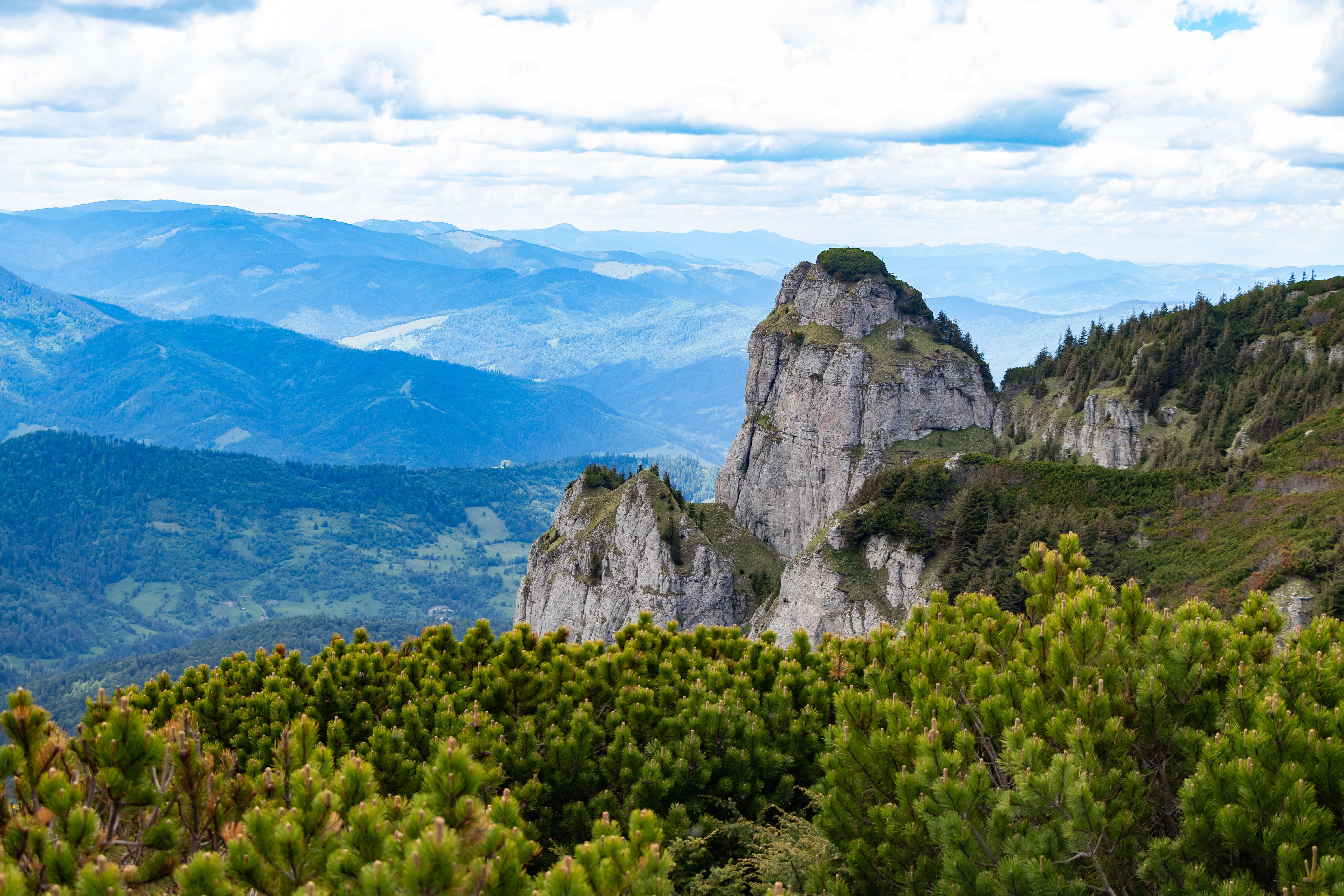 Breathtaking landscape of Ceahlău Mountain in Romania, showcasing lush forests and rocky peaks.