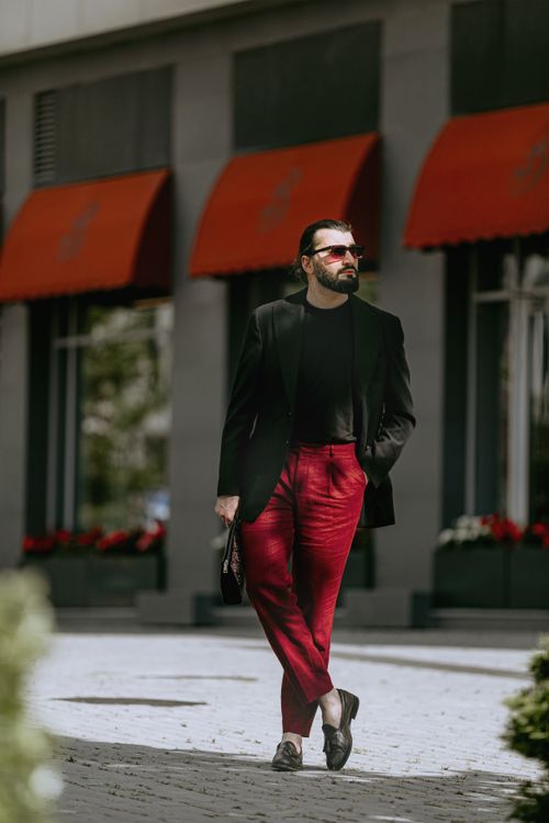 Free Fashionable man with sunglasses and red pants strolling on a street in Baku, Azerbaijan. Stock Photo