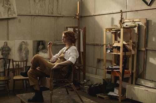 Женщина в белом с длинным рукавом, сидя на коричневом стуле