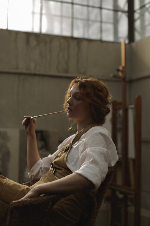 Side view Photo of a Woman Holding Paintbrush