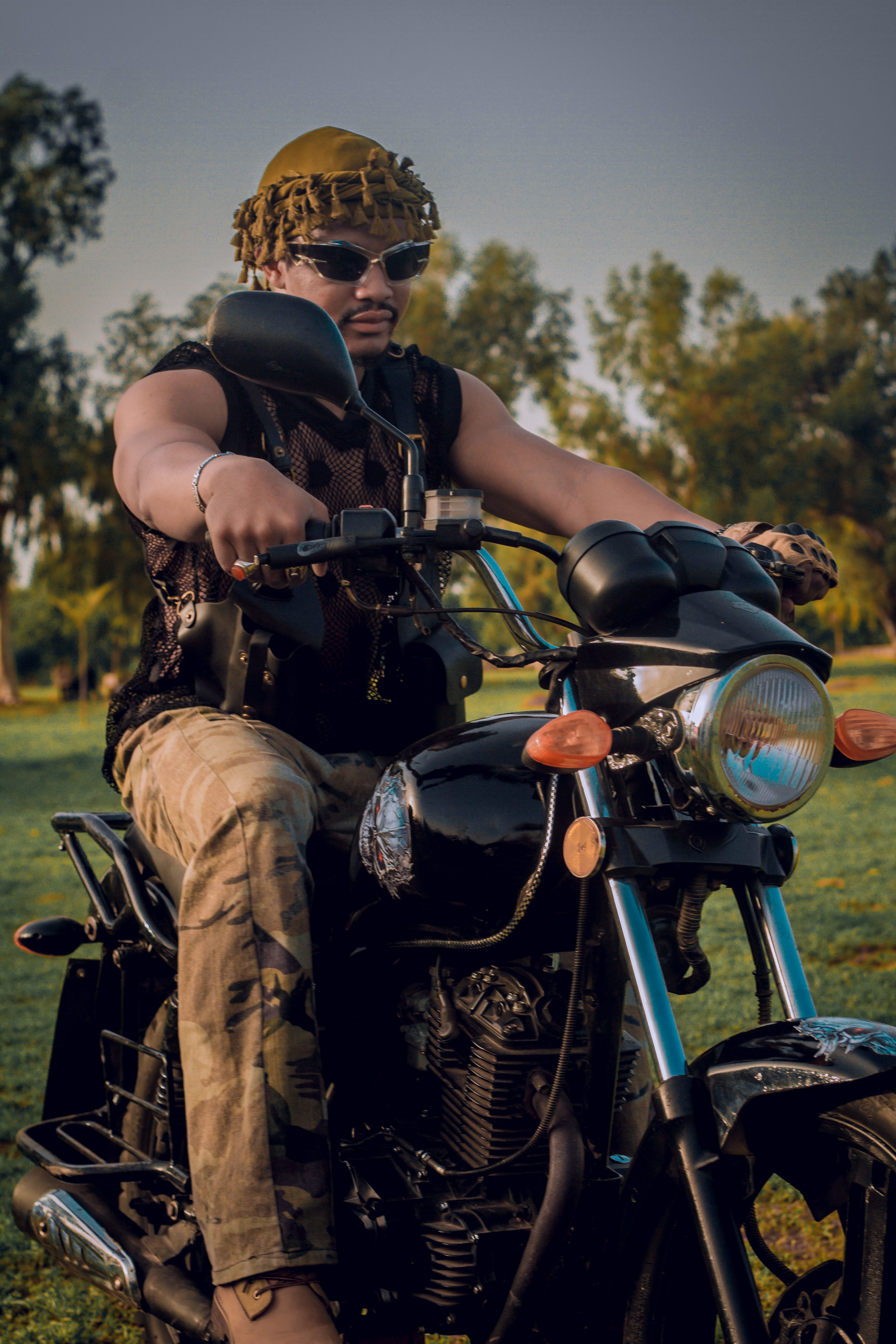 A man in military attire rides a motorcycle outdoors in Zaria, Nigeria.