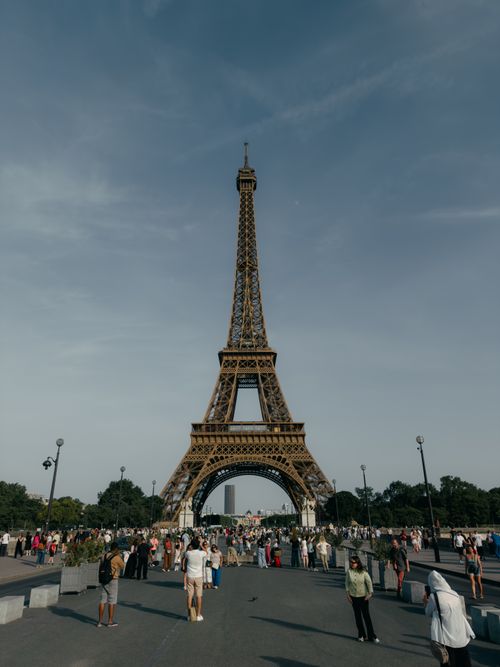 Free The iconic Eiffel Tower with tourists on a clear day in Paris. Stock Photo