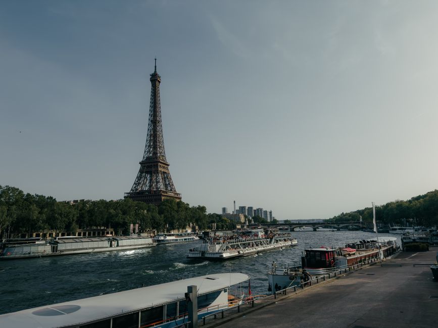 Scenic view of the Eiffel Tower and boats on the Seine River in Paris during the day.