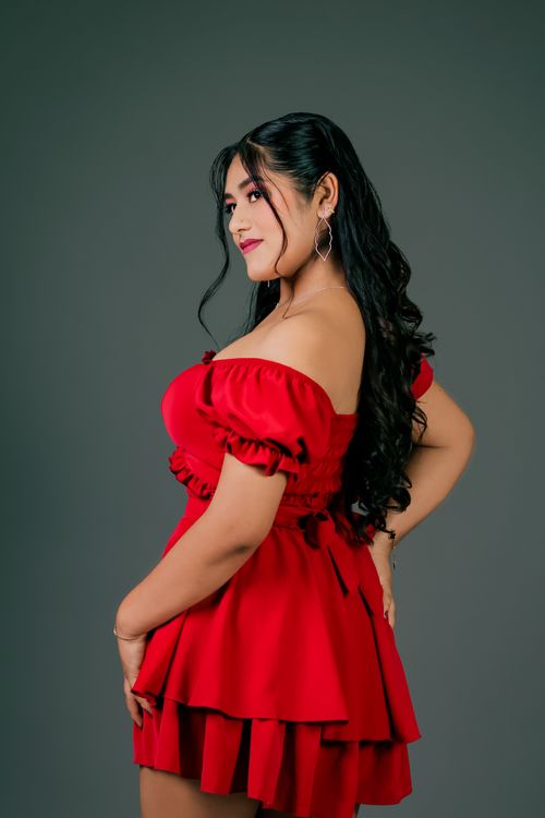 Free Side profile of a woman in a stylish red dress with a confident pose. Stock Photo