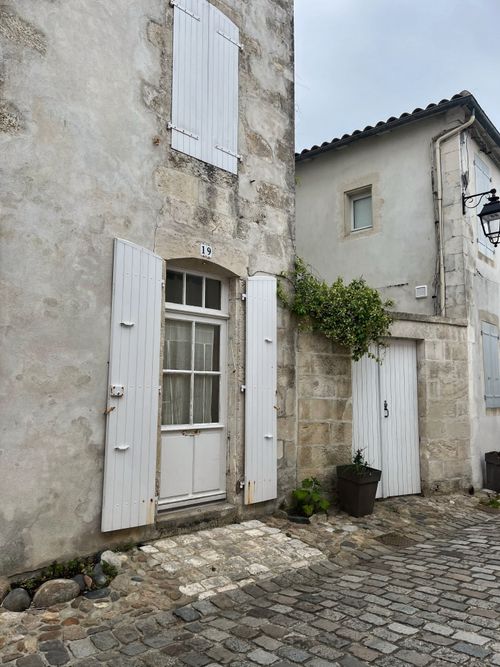 Free Historic stone house facade with cobblestone street in Nouvelle-Aquitaine, France. Stock Photo