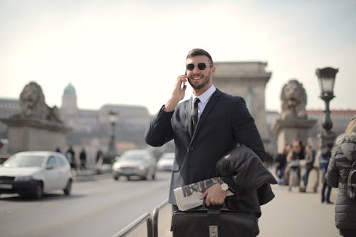 Man In Zwart Pak Jasje En Zwarte Zonnebril Tijdens Het Gebruik Van Smartphone