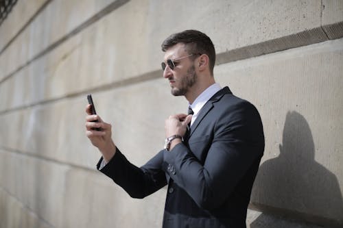 Man in Black Suit Jacket Holding Smartphone