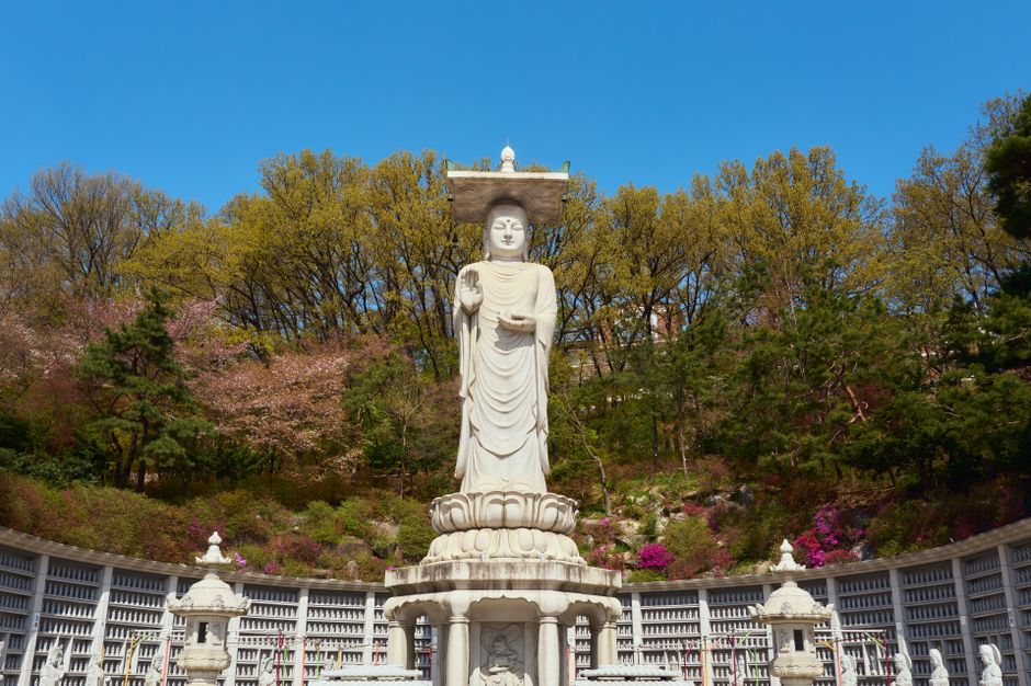 Serene stone Buddha statue inside a traditional Korean temple grotto.