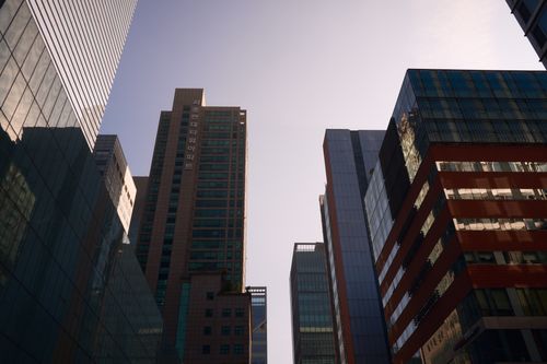 Free Modern skyscrapers with glass facades reflecting daylight in a bustling cityscape. Stock Photo
