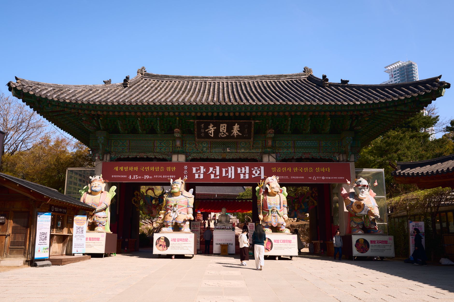 Front view of a traditional Korean temple gate adorned with large guardian statues.