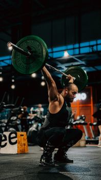 A focused man lifting weights in a stylish gym environment during the day.