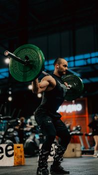 Fitness enthusiast lifting weights in gym environment, showcasing strength and focus.
