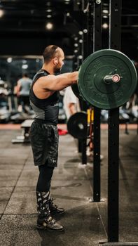 A muscular man lifting a barbell in a modern gym, showcasing strength and focus.