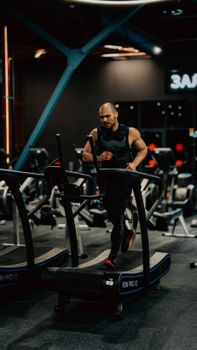 A determined man running on a treadmill in a modern gym setting, emphasizing fitness and energy.