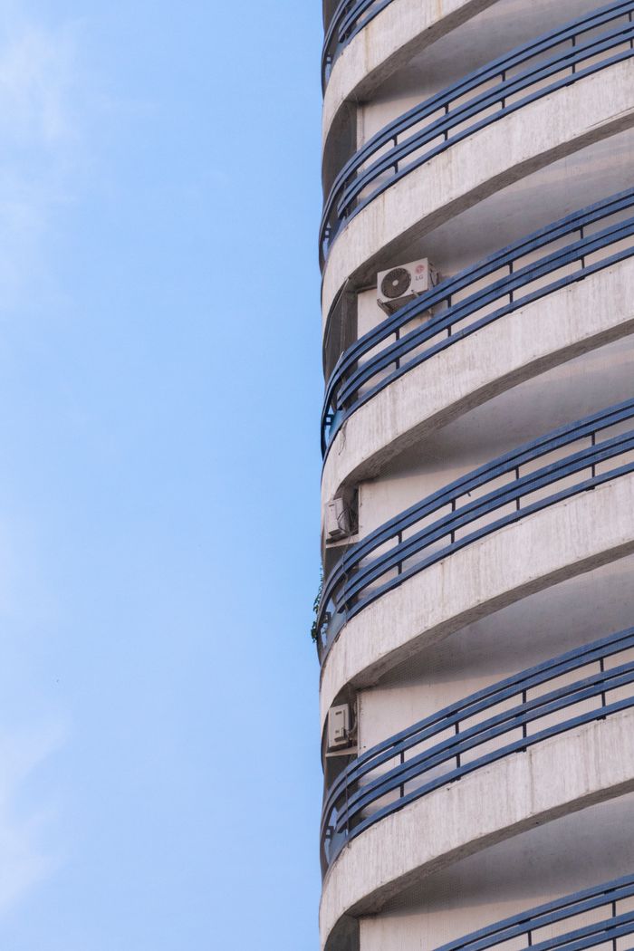 Curved modern architectural facade against a clear blue sky in Bengaluru