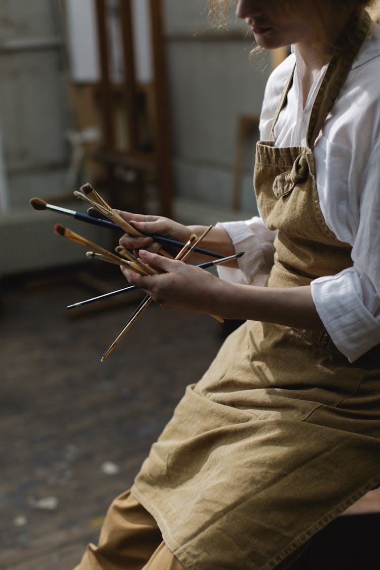 Person Holding Paint Brushes