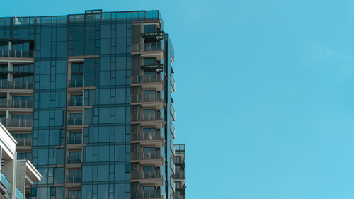 Free Contemporary urban skyscraper with reflective glass and clear blue sky. Stock Photo