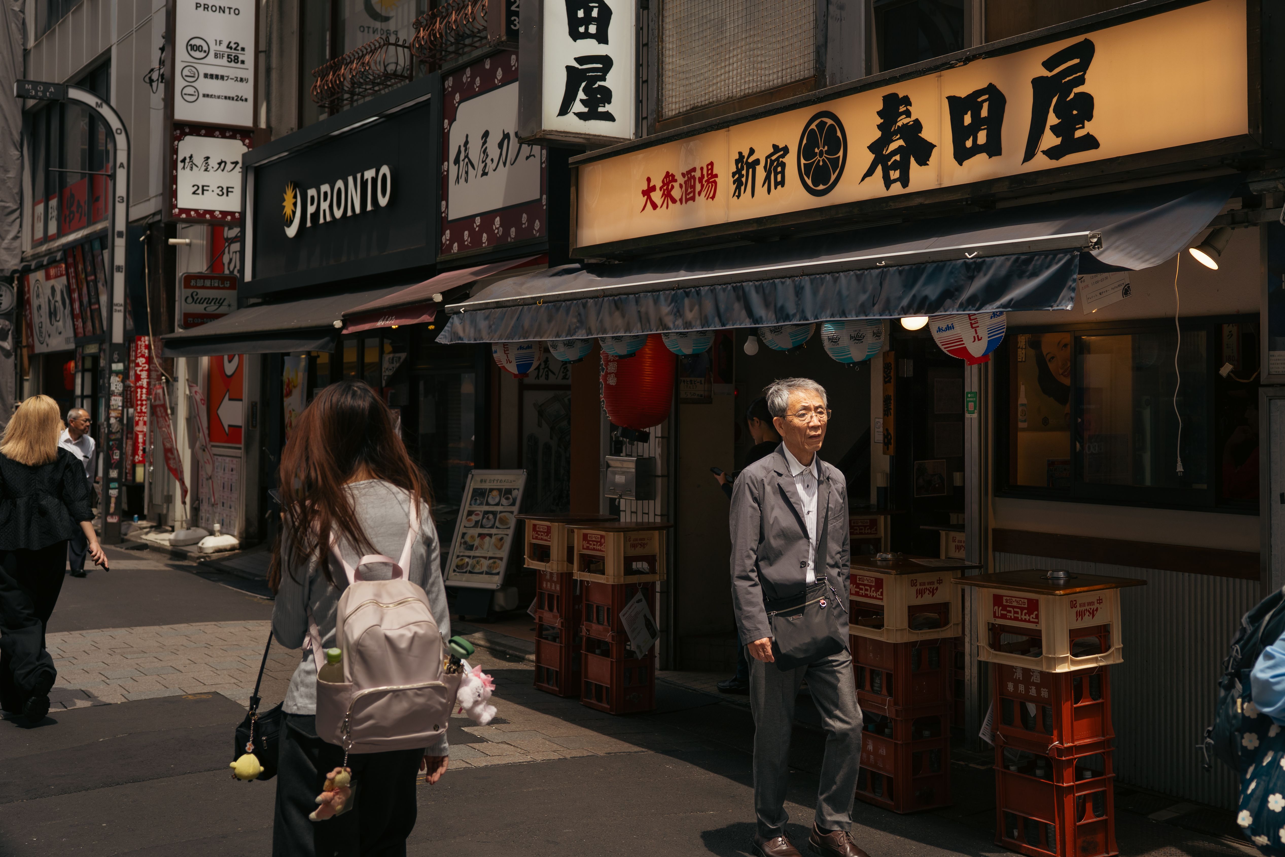 People walking past shops in Shinjuku, Tokyo. Vibrant urban life captured in Japan.