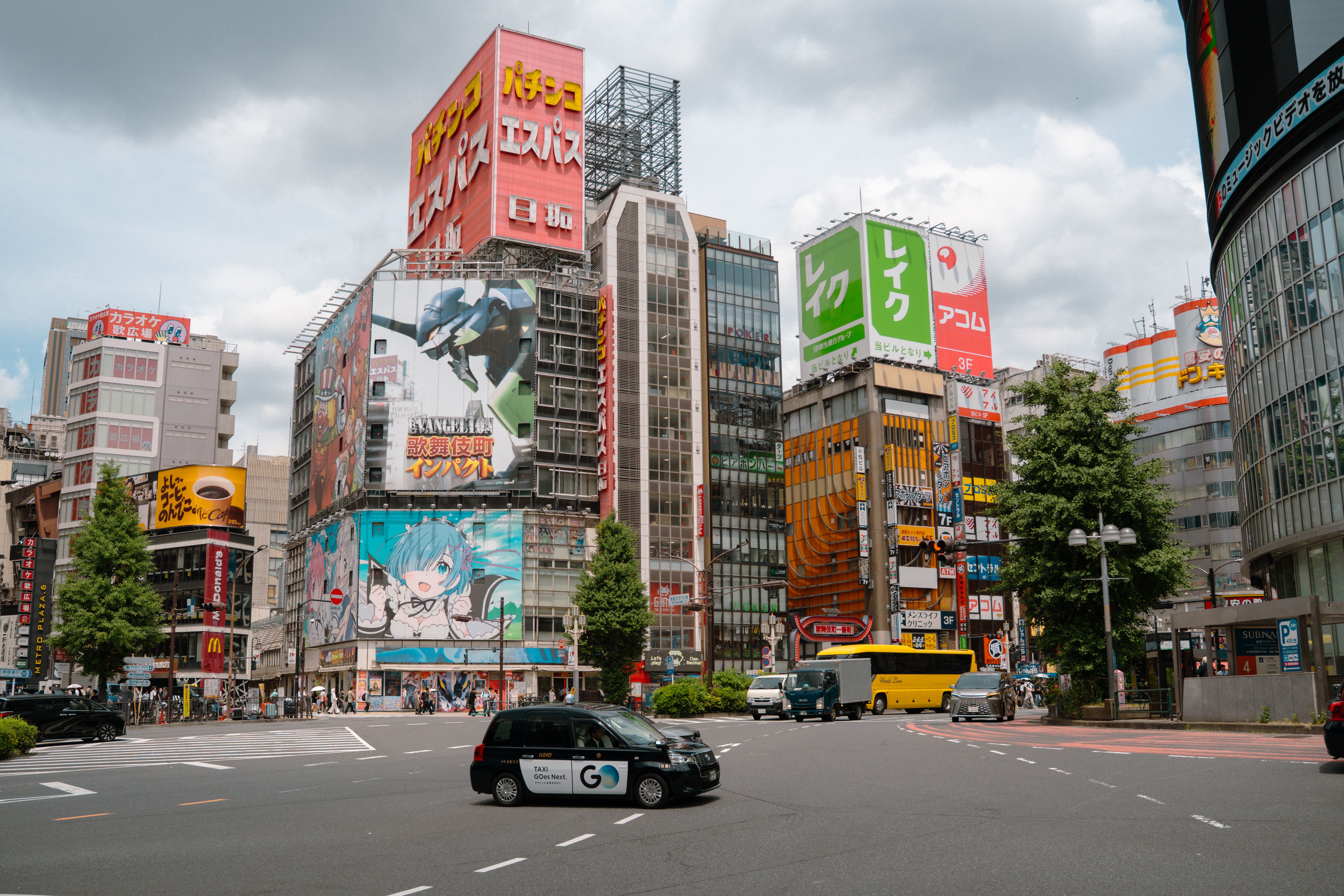 Vibrant street scene in Shinjuku, Tokyo, with colorful billboards and traffic.