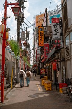 Lively street view capturing the essence of Tokyo's urban life with shops, signs, and pedestrians.