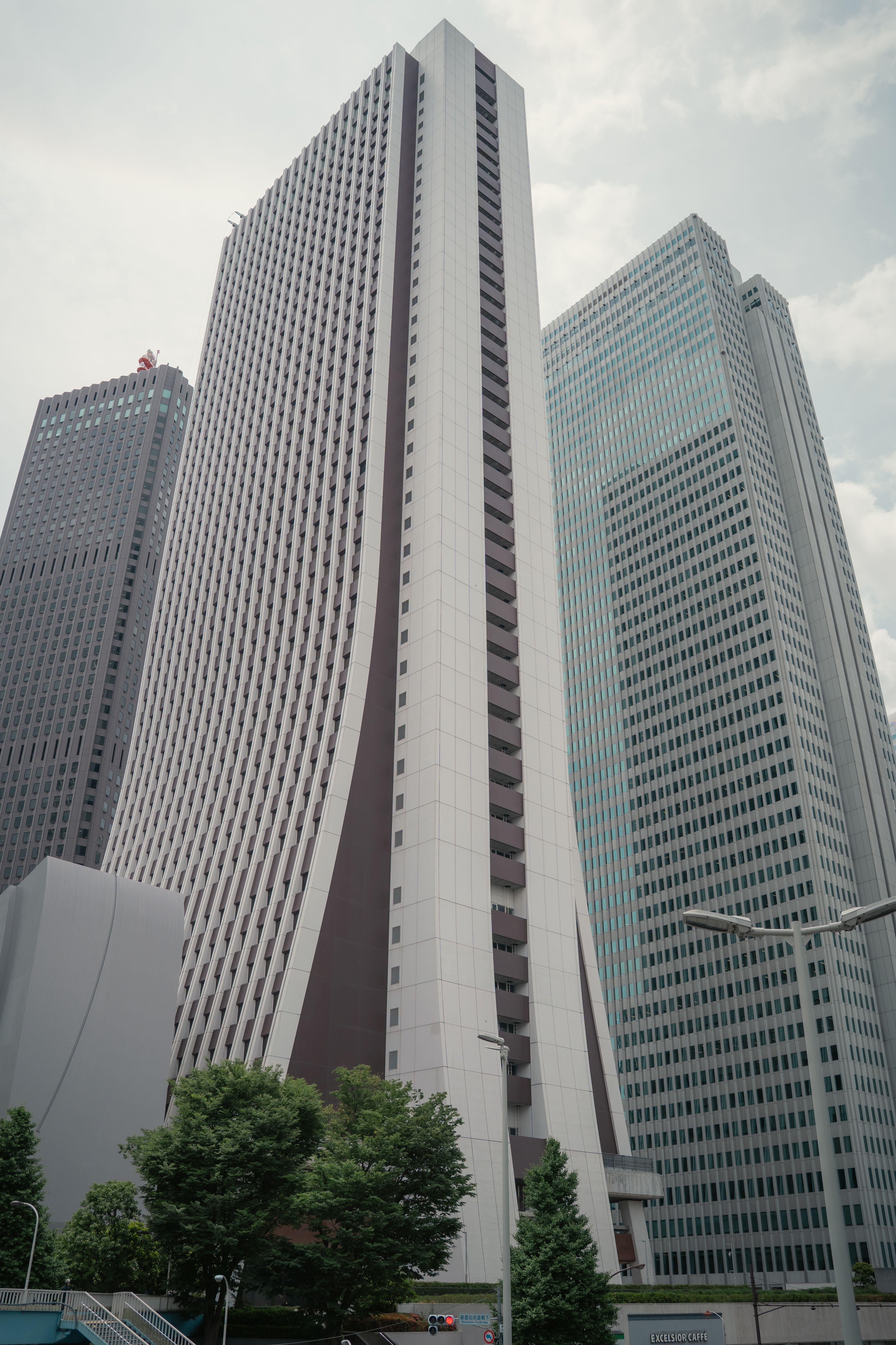 東京の高層ビル群の独特な建築デザイン。好調な企業業績を背景に、経済の中心地としての活気を感じさせる都市景観のイメージ。