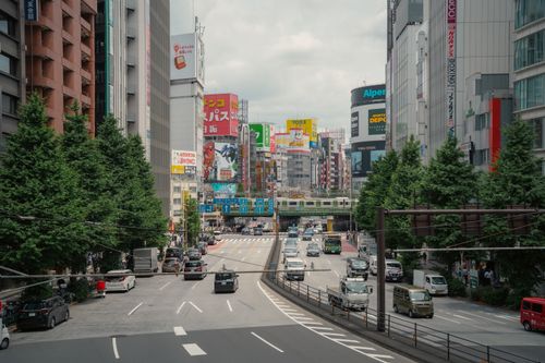 Free Vibrant street view of Shinjuku, Tokyo, showcasing lively urban life with bustling traffic and colorful billboards. Stock Photo