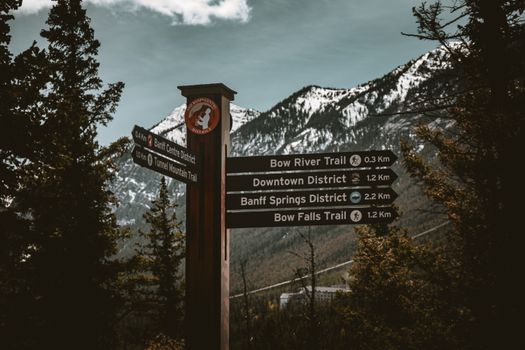 Trail signs guide hikers through Banff National Park's stunning mountain landscape in Alberta, Canada.