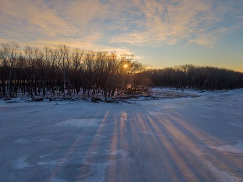 Free Captivating winter sunset casting long shadows over a frozen river in West Newton, Minnesota. Stock Photo