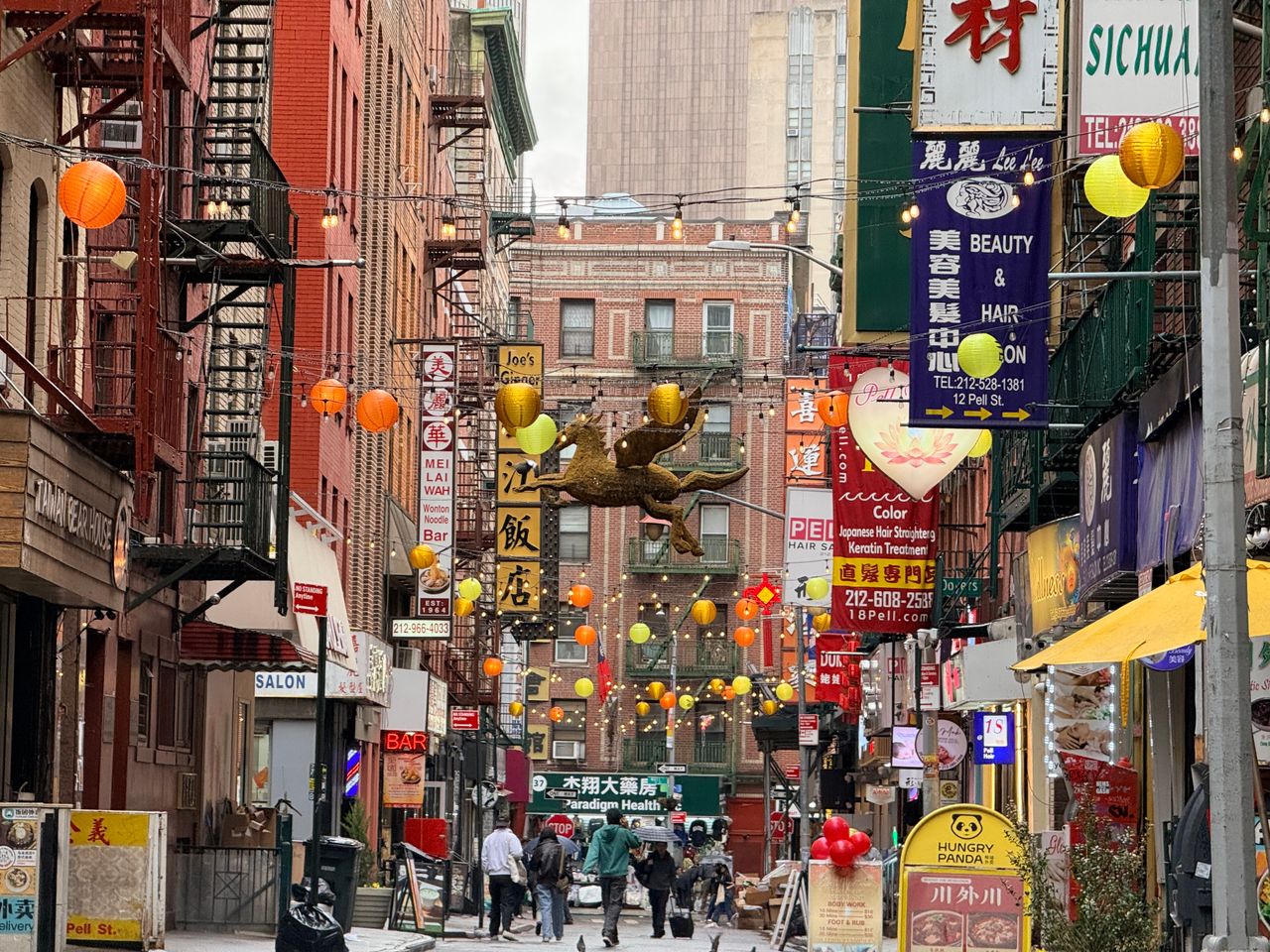 a bustling street in chinatown nyc full of colorful lanterns and livel