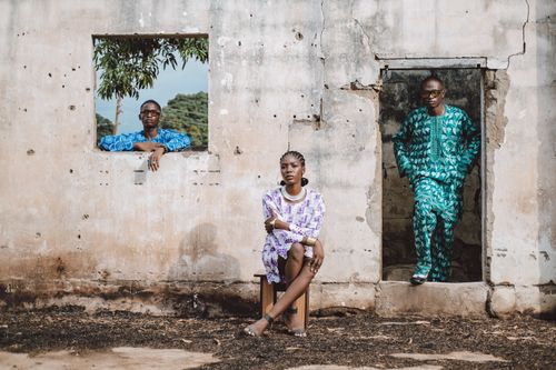 Free Three individuals showcase vibrant traditional African attire in an outdoor setting. Stock Photo