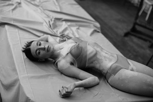 Bezpłatne Kobieta W Białym Podkoszulku Bez Rękawów, Leżąc Na łóżku Zdjęcie z galerii