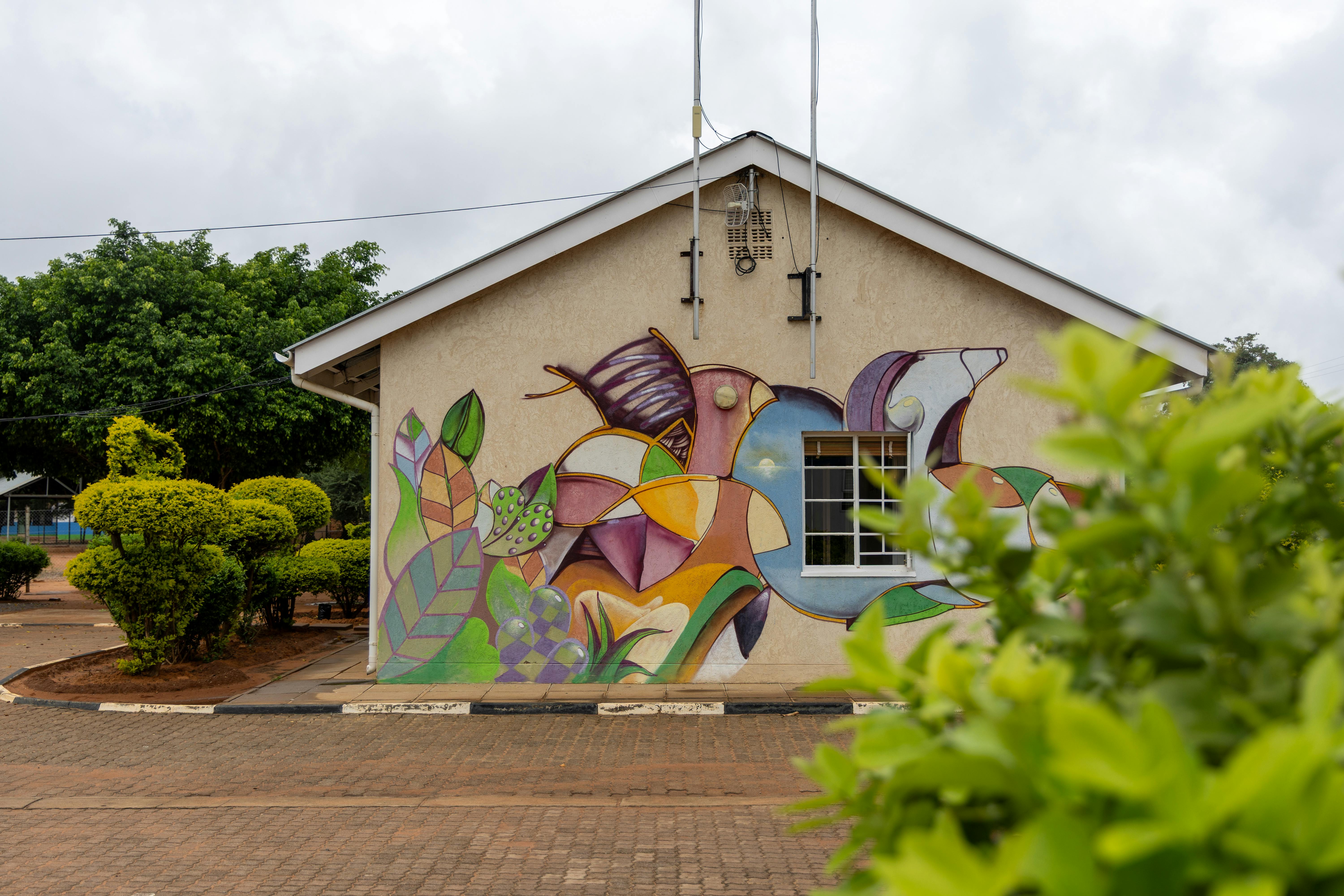 A vibrant mural decorates the side of a building in Mochudi, Botswana, outdoors.