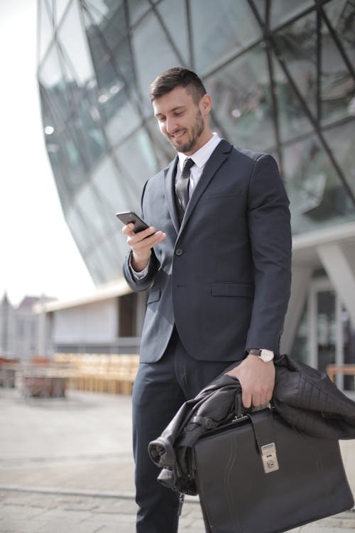 Free Man in Black Suit Jacket Holding Smartphone Stock Photo