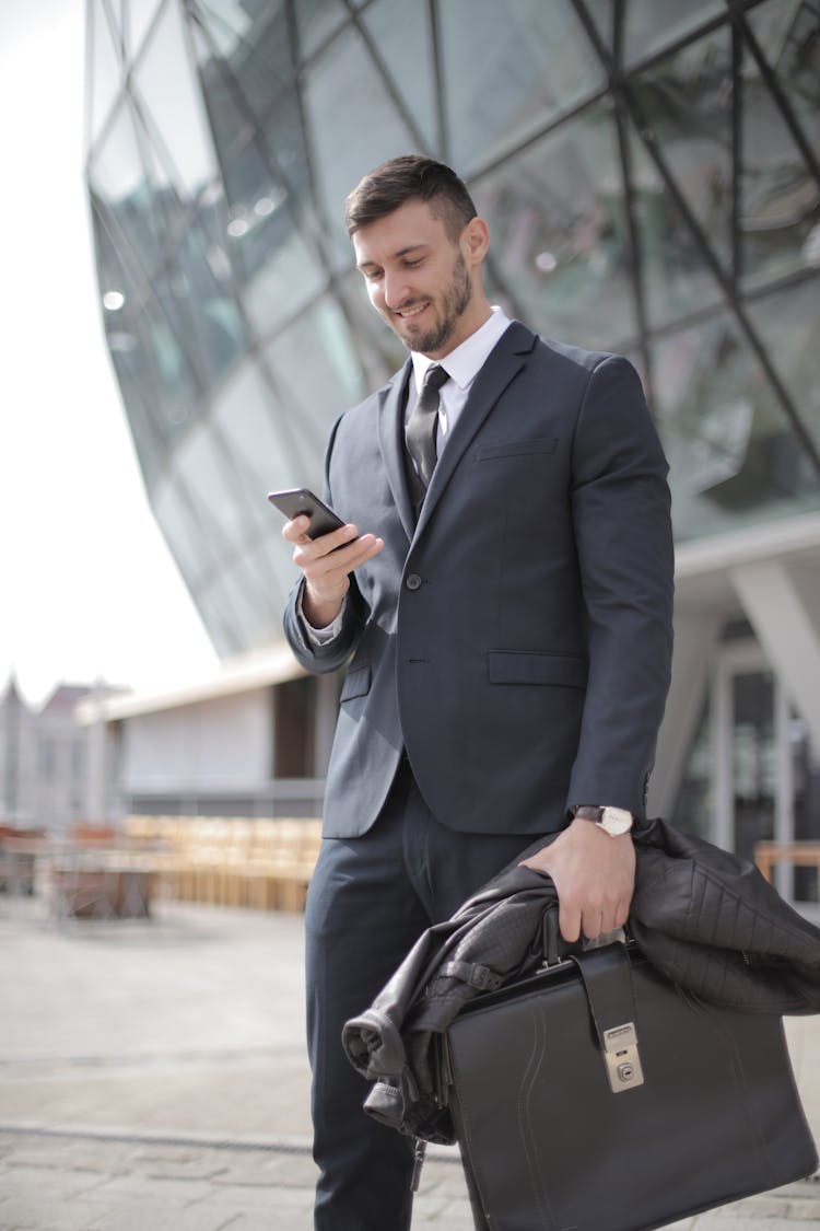 Man In Black Suit Jacket Holding Smartphone