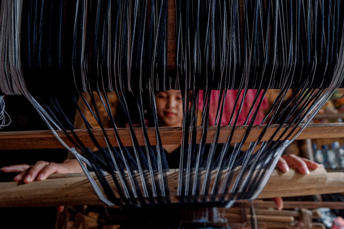 Artisan tissant à la main sur un métier à tisser traditionnel