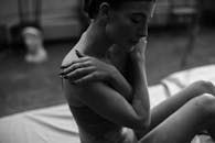 一幅展现女性沉思姿态的艺术灰度肖像，突出了自然的皮肤纹理