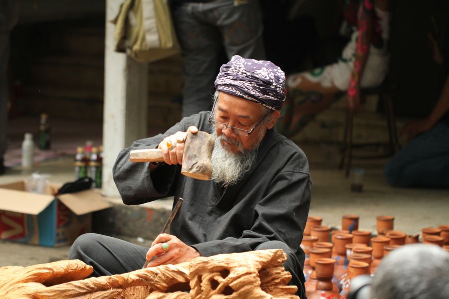 Perajin kayu senior sedang mengukir